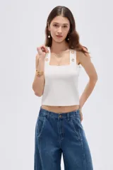Top de rayón color blanco, de corte ajustado al cuerpo, con escote cuadrado y tirantes anchos decorados con botones metálicos dorados.