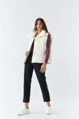 Chaleco blanco con cuello alto y bolsillos laterales.