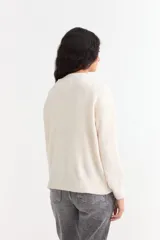 Sweater de punto color bordó con diseño de ochos en el frente y mangas, cuello redondo y puños acanalados.