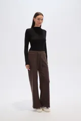 Pantalon de corte holgado y tiro alto, confeccionado en tejido de poliester con textura acanalada. Presenta cintura elástica con cordón de ajuste y diseño de pierna ancha.