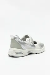 Zapatillas deportivas negras con suela blanca de 4cm de alto y tira ajustable con velcro.