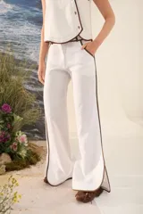 Pantalón azul marino de corte wide leg con detalles en tono marrón tostado en la cintura, bolsillos y bordes laterales, cuenta con trabillas para cinturón y cierre frontal.