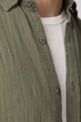 Camisa de manga larga confeccionada en tejido de lino con textura, de corte holgado y diseño versátil con cierre frontal de botones.