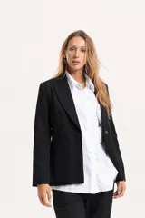 Blazer de corte sastrero con calce entallado, solapas clásicas, cierre frontal de un botón y bolsillos delanteros con vivo.