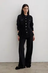 Pantalón de jean negro de corte recto y tiro medio, con cierre frontal de botón y cremallera, y bolsillos laterales y traseros.
