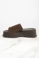 Zueco con plataforma color marrón, capellada de gamuza y plantilla con la inscripción "Lemon".