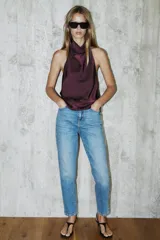 Jeans de tiro alto con corte mom fit, diseño de cinco bolsillos y detalle de raya planchada frontal. Cierre frontal con cremallera y botón.