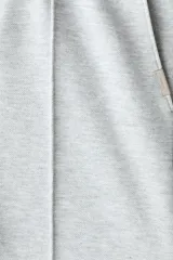 Pantalón tipo jogger de punto de peso medio con pliegue frontal cosido, cintura elástica con cordón de ajuste, bolsillos laterales y bolsillo trasero insertado.
