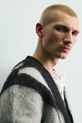 Cárdigan de punto con acabado cepillado, diseño de jacquard con patrón abstracto de ondas en gris y negro, cuello en pico, manga larga y cierre frontal con botones.