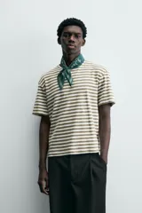 Camiseta de manga corta con cuello redondo y calce relajado, confeccionada en tejido de rayas horizontales blancas y negras.