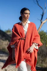 Ruana de tejido artesanal con textura en relieve, color naranja, con flecos en el ruedo y diseño envolvente.