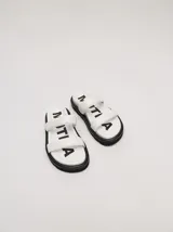 Sandalias de cuero vacuno color marrón con acabado brillante, diseño de dos tiras anchas acolchadas y plataforma baja.