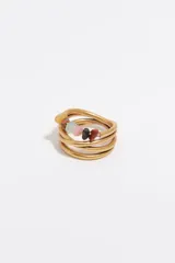 Anillo de metal dorado acabado mate, con diseño multicapa y detalles de piedras naturales de colores.