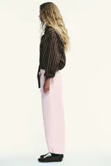 Pantalón de felpa de tiro alto con cintura elástica y corte recto. Cuenta con bolsillos laterales ocultos en la costura y bajo ajustable con cordón elástico y stoppers.