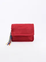 Bandolera roja de tela acolchada con solapa y cierre magnético. Incluye correa de hombro ajustable y extraíble, y detalle de borla de cordones de colores.