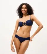 Bombacha de bikini azul marino confeccionada en microfibra texturizada, con laterales drapeados y anchos que aportan mayor comodidad. Cuenta con forro interno y detalle de medalla metálica en la parte posterior.