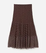 Falda midi de tul con estampado de corbatas, cintura elástica y diseño con volados. Presenta un forro más corto que crea un efecto de transparencia en el ruedo.
