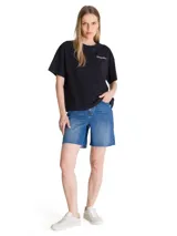 Remera negra de corte boxy y diseño liso, con cuello redondo y mangas cortas. Cuenta con un pequeño logo bordado en contraste sobre el pecho y parche bordado en la manga.