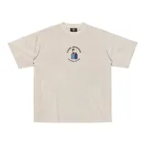 Remera de corte amplio color crema con estampado en el pecho que incluye el texto 'Kaboa Industries' y 'Más barrio que moda'.