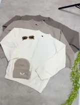 Sweater de punto liso con cuello redondo y mangas largas, de calce relajado y textura suave.