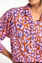 Camisa de viscosa color naranja con estampado animal print en tonos rosa y azul. Corte oversize, cuello clásico y cierre frontal con botones.