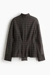 Blusa de tejido liviano color negro con patrón de cuadros blancos, corte oversized con hombros caídos, cuello drapeado con tira para atar, manga larga con puños anchos y cintura entallada.