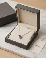 Collar de plata 925 con cadena fina y dije redondo tipo punto de luz con circonia central en color violeta.
