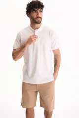 Chomba de piqué color blanco, con cuello polo y cierre frontal con tres botones.