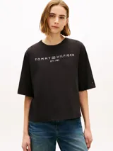 Remera negra de corte amplio de la marca Tommy Hilfiger, confeccionada en punto de puro algodón. Presenta cuello redondo, mangas cortas y anchas con hombros ligeramente caídos, y el logo de la marca estampado en el pecho en color blanco.