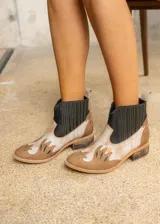 Botas cortas de cuero vacuno color beige con detalles de recortes en cuero blanco y negro. Elásticos laterales negros y taco bajo de madera.