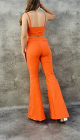 Pantalón Oxford de tiro alto, color rojo, con corte ajustado en la parte superior y acampanado en la parte inferior.