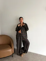 Pantalón de corte recto y holgado, confeccionado en tela de viyela con estampado de cuadros en tonos negro, gris y blanco. Presenta cintura elástica para mayor comodidad.