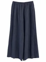 Pantalón azul marino de lino, con cintura elástica fruncida, corte amplio y detalle de pliegues pespunteados laterales.