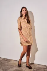 Vestido camisero corto con estampado tipo toile de Jouy a rayas, mangas cortas y cierre frontal con botones.