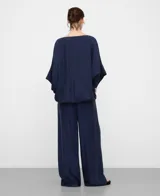 Blusa amplia de color azul marino, con escote barco, manga japonesa y bajo abullonado con elástico interior.
