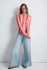 Remera de punto fino de manga larga y cuello redondo, con diseño de rayas verticales en tonos rosados, rojos y naranjas.