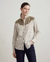 Camisa de manga larga con diseño de rayas verticales, confeccionada en algodón. Presenta un canesú superior en lana con estampado de cuadros en tonos tierra, cuello alto con volados y cierre frontal con botones.