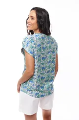Blusa estampada con flores azules y verdes, de manga corta con cierre metálico en el frente.