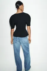 Camiseta negra de cuello redondo con escote en pico, manga corta abullonada y bajo con diseño peplum.