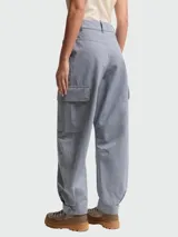 Pantalones de estilo cargo confeccionados en tejido de cambray color gris azulado. Presentan un corte holgado, bolsillos laterales con solapa y cierre frontal con botón y cremallera.