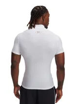 Remera de compresión Under Armour de manga corta, color blanco, con cuello alto y logo de la marca estampado en el cuello. Confeccionada en tejido técnico elástico y transpirable con costuras planas ergonómicas.