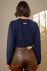 Remera de algodón con cuerpo en color beige y mangas largas abullonadas en color blanco. Presenta cuello redondo con frunces y puños elásticos.
