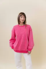 Sweater de tejido suave con lavado efecto vintage, color rosa fucsia, de calce oversize y cuello redondo.