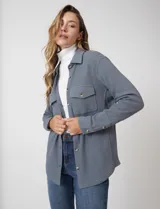 Sobrecamisa de tela texturada tipo waffle, color gris, con cuello camisero, cierre frontal con botones y bolsillos frontales con solapa.