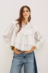 Camisa de algodón con diseño de encaje bordado, cuello mao, cierre frontal de botones y mangas largas con puños con volados.