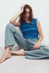 Jeans de denim de tiro medio y corte relaxed con diseño de cinco bolsillos, trabillas en la cintura y cierre frontal con cremallera y botón metálico.