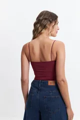 Top negro de tirantes finos con diseño de escote fruncido y abertura cut-out triangular en el centro del pecho. Confeccionado en tejido elástico, presenta un corte ajustado al cuerpo.