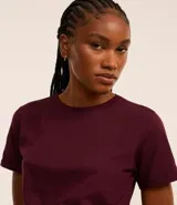 Remera tipo t-shirt de algodón, color beige claro, con cuello redondo y mangas cortas dobladas.