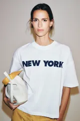 Remera oversize blanca de algodón con cuello redondo, manga corta y estampa con la inscripción 'NEW YORK' en color negro en el frente.