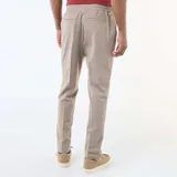 Pantalón de corte jogger en color beige, confeccionado con cintura elástica ajustable mediante cordón y bolsillos laterales.